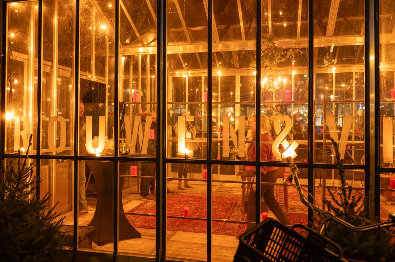 Het warme interieur van de kas met kaarsen en handgeschreven herinneringen
